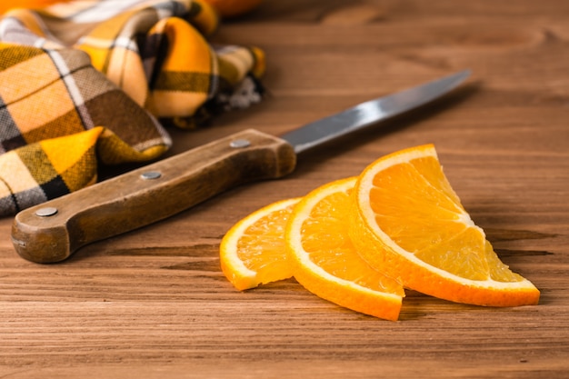 Gesneden sinaasappel, mes en servet op een houten tafel