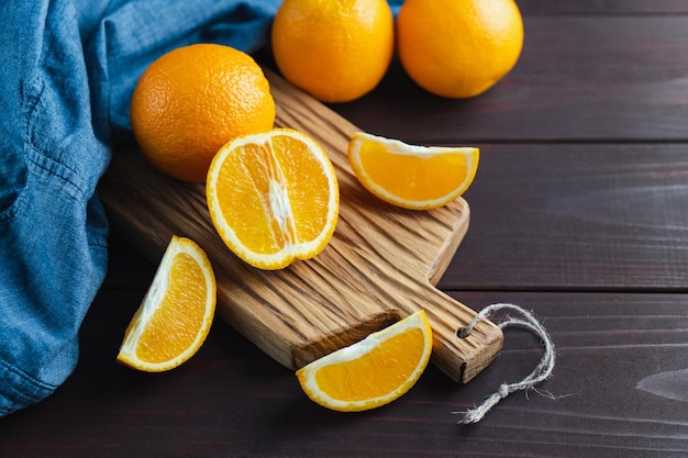 Gesneden sinaasappelfruit in de buurt van denimtextiel op een houten bord Oranje sappig fruit citrus minimaal concept