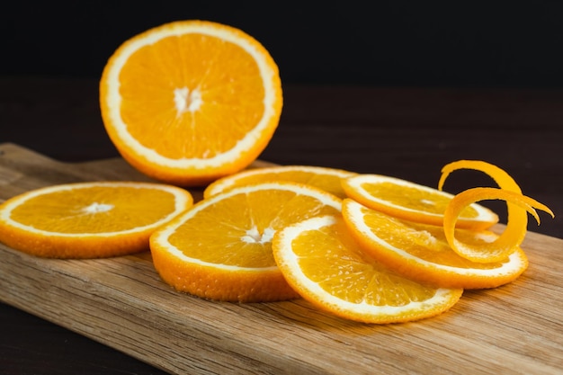 Gesneden sinaasappels fruit en schil op een houten bord Sinaasappel sappig fruit citrus minimaal concept