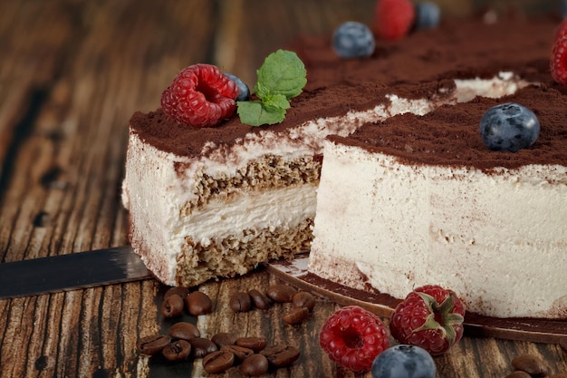 Gesneden stuk tiramisu cake op houten achtergrond