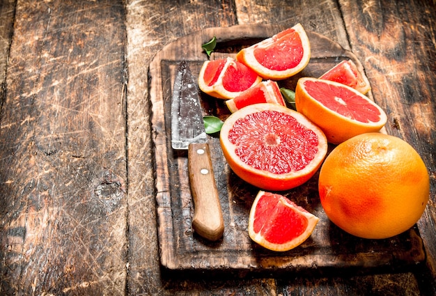 Gesneden stukjes grapefruit met een mes.