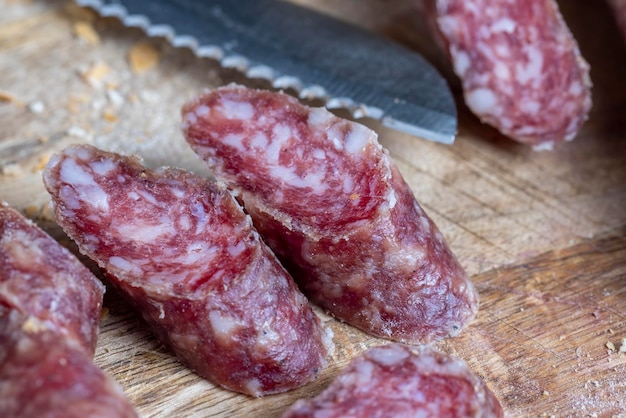 Gesneden stukjes worst van vlees liggen op een snijplank varkensvlees met spek is gedroogd en verdord het vlees is klaar om te eten