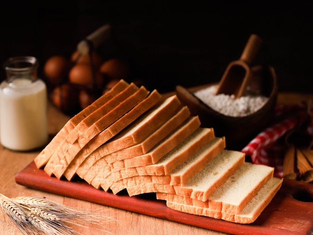 Gesneden Toast Loaf Witbrood (Shokupan of Roti Tawar) voor het ontbijt op houten achtergrond, geserveerd met ei en melk. Bakkerij Concept Afbeelding