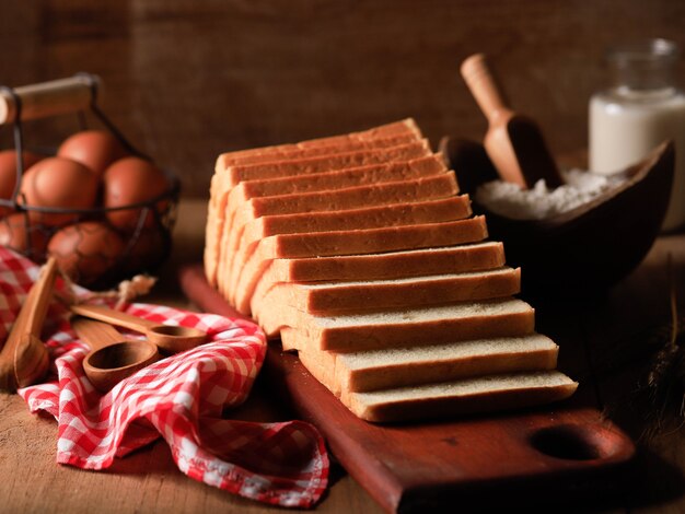 Gesneden Toast Loaf Witbrood (Shokupan of Roti Tawar) voor het ontbijt op houten achtergrond, geserveerd met ei en melk. Bakkerij Concept Afbeelding