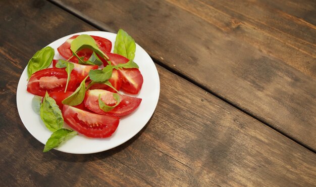 Gesneden tomaten met sla op een witte plaat. gezond eten concept