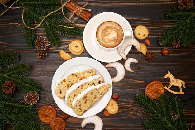 Gesneden traditionele kerststolcake met marsepein en gedroogd fruit met nieuwjaarsversieringen