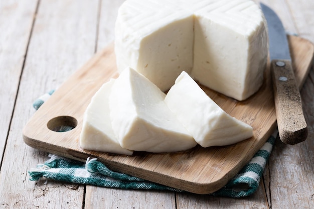 Gesneden verse witte kaas van koemelk op houten tafel