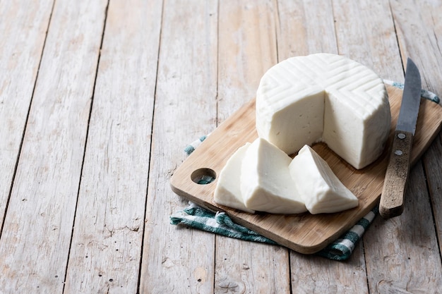 Gesneden verse witte kaas van koemelk op houten tafel