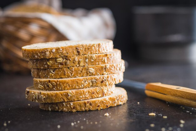 Gesneden volkoren brood Smaakvolkoren gebak met zaden op de zwarte tafel