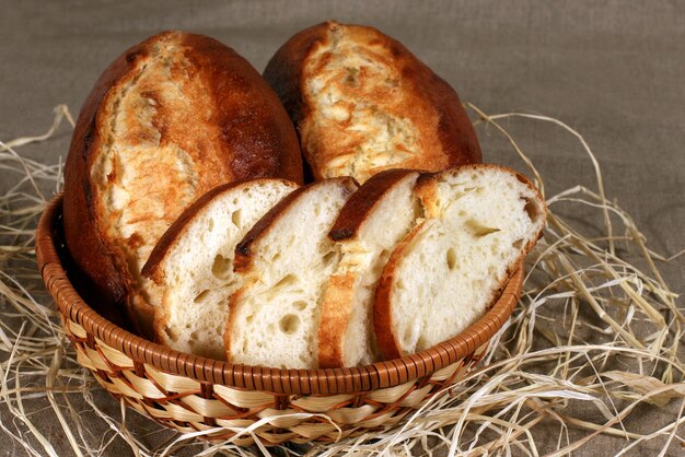 Gesneden witbrood ligt in een rieten mand op het tafelkleed grijs linnen