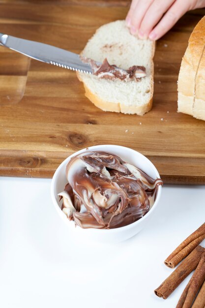 Gesneden witbrood met gesmeerde chocoladeboter, heerlijke chocoladeboter en witbrood, natuurlijke chocoladepasta met cacao tijdens het ontbijt