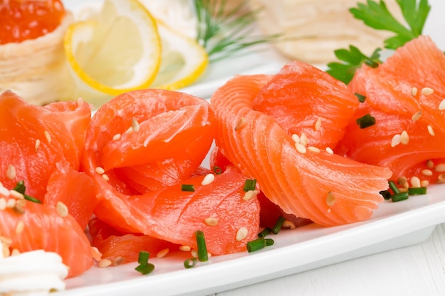 Gesneden zalm met sesamzaadjes op een wit bord