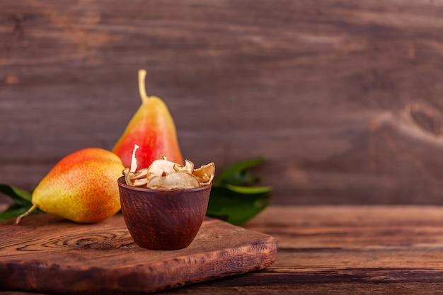 Gesneden zelfgemaakte gedroogde vruchten in houten kop, houten rode peren