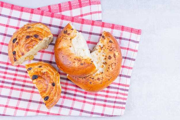 Gesneden zoete broodjes op een theedoek, op het marmer.