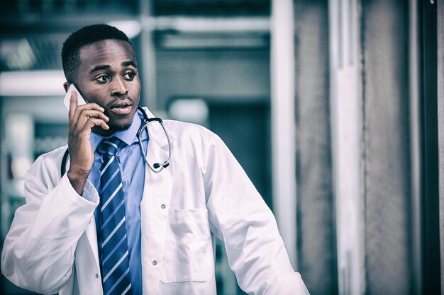 Gespannen arts die op mobiele telefoon spreekt