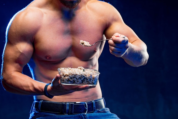 Gespierde bodybuilder die gezonde witte rijst eet Gezond levensstijlconcept