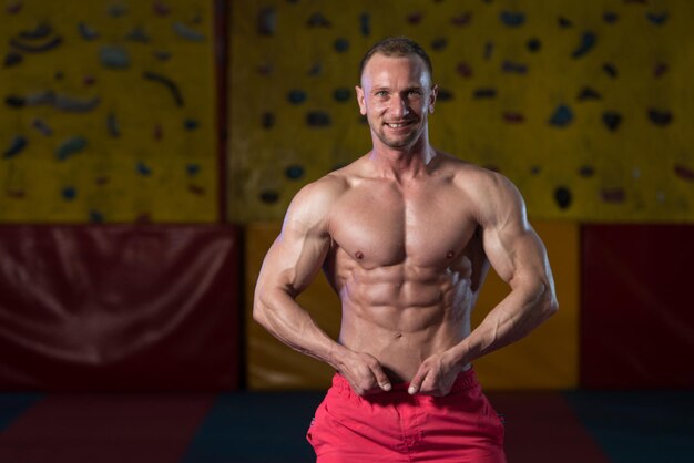 Gespierde bodybuilder die zijn voorste buikspieren toont