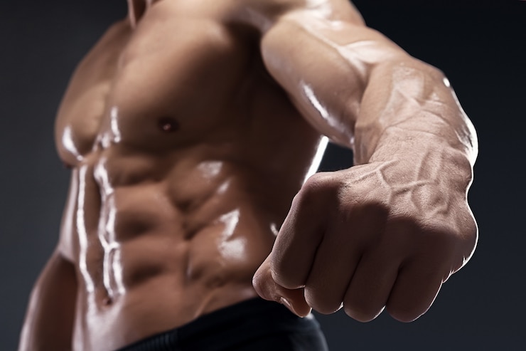 Foto gespierde bodybuilder toont zijn vuist en aderen