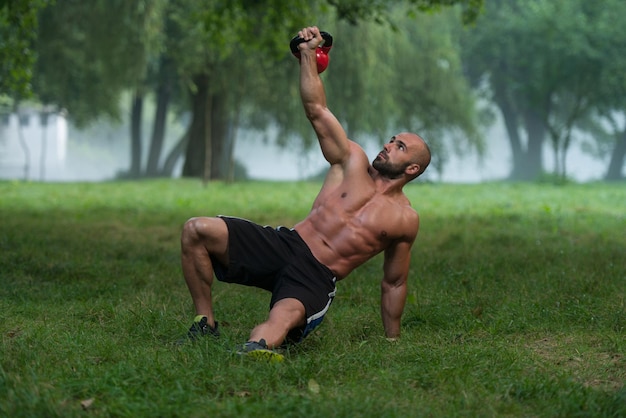 Gespierde Fitness Man Balanceert Kettlebells Met Een Hand Oefening Buitenshuis