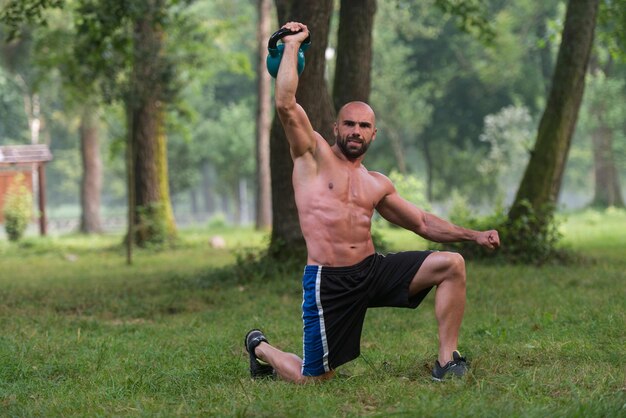 Gespierde Fitness Man Balanceert Kettlebells Met Een Hand Oefening Buitenshuis