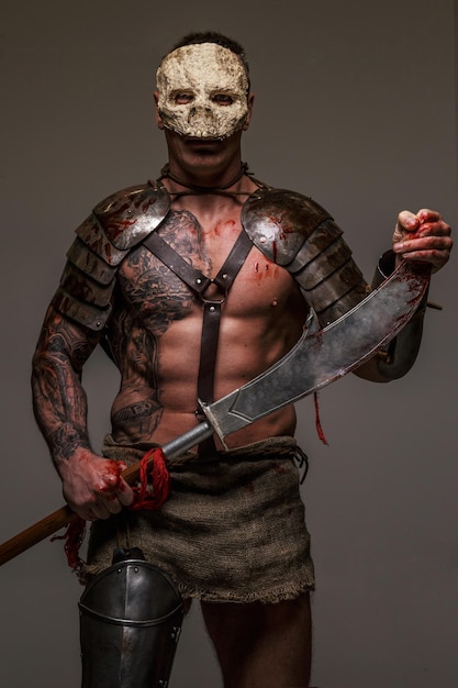 Gespierde gladiator in schedelmasker met zwaard