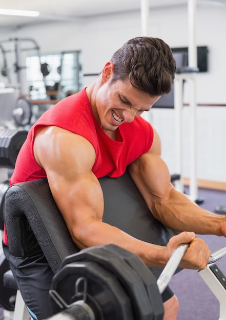 Gespierde man barbell op te heffen in de sportschool