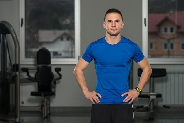 Gespierde man in sportoutfit in fitnesscentrum