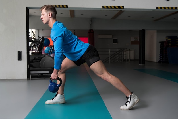 Gespierde man oefenen met kettlebell