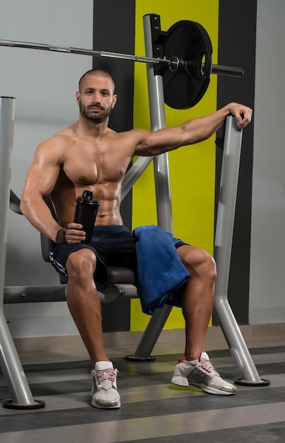 Gespierde man rust na het sporten en drinken uit shaker