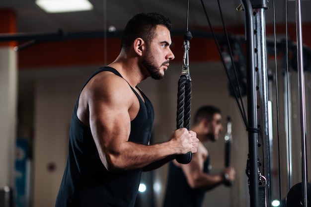 Gespierde man tijdens een training in de sportschool traint de triceps