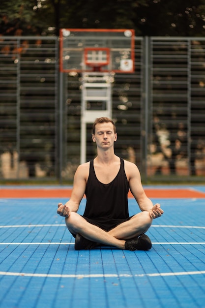 Gespierde man zittend in lotus yoga positie