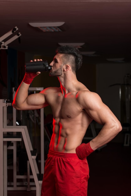 Gespierde mannen die water uit Shaker drinken