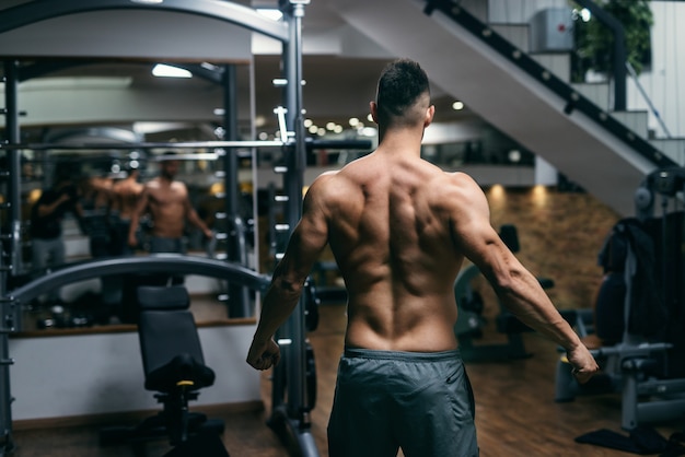 Gespierde shirtless man poseren in de sportschool