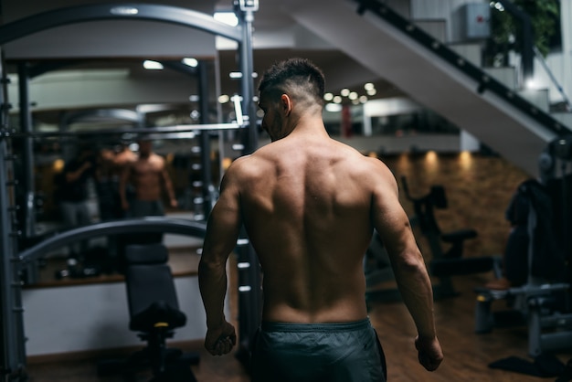 Gespierde shirtless man poseren in de sportschool