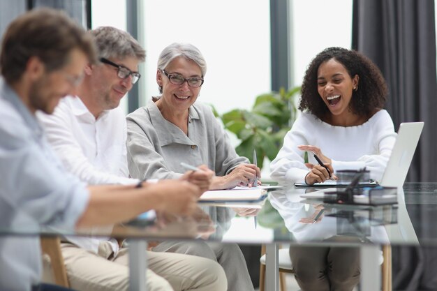 Gesprek tussen managers en medewerkers op kantoor aan tafel