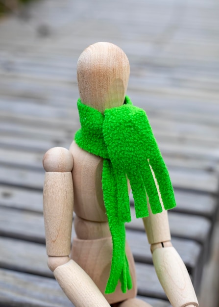 Photo gestalta figure in green scarf sitting in park bench