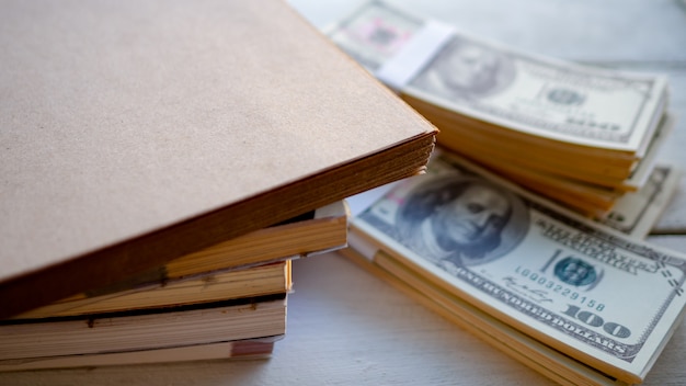 Foto gestapelde boeken met dollargeld geplaatst op de lijst