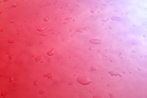 Foto gestemde druppels water op een rood oppervlak