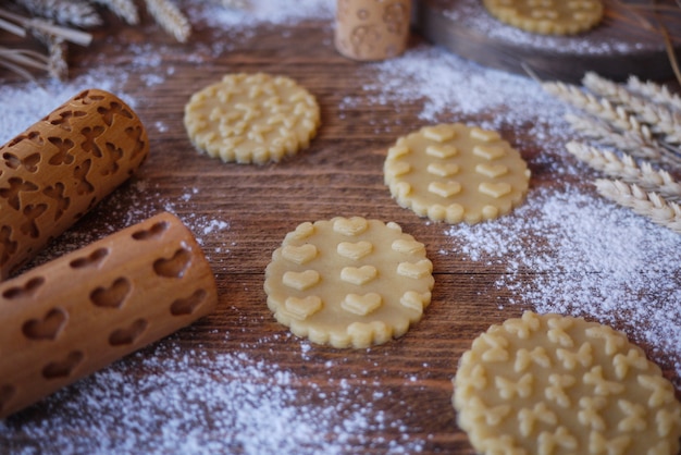 Gestempelde koekjes met een print van harten en vlinders. houten deegrollen voor cookies