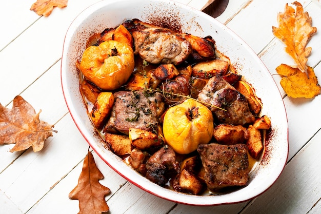 Gestoofd varkensvlees met herfstkweepeer. Gegrild vlees in ovenschaal