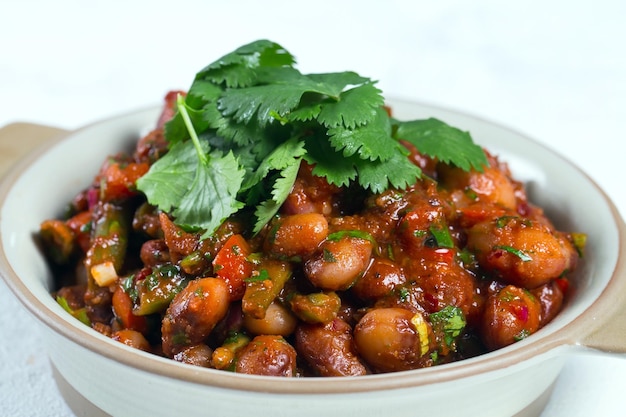 Gestoofde tuinbonen in tomatensaus met kruiden en specerijen close-up,