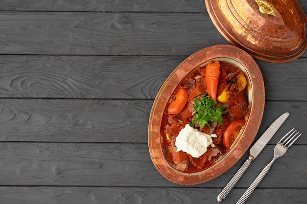 Gestoomd vlees met groenten in tomatensaus op houten oppervlak