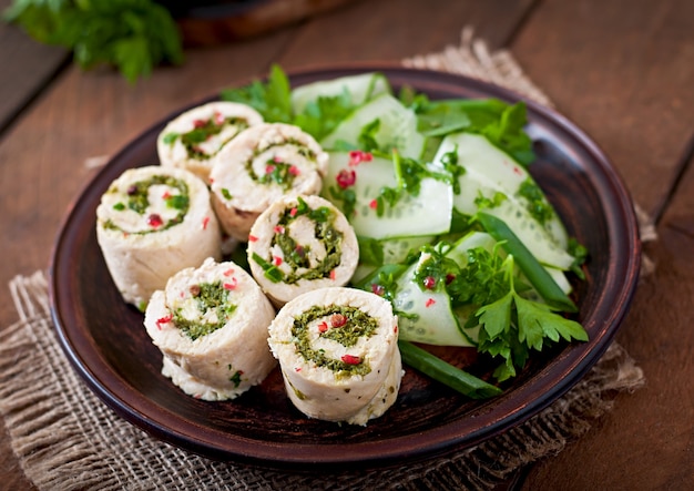 Gestoomde kippenbroodjes met greens en verse groentesalade op een bruine plaat