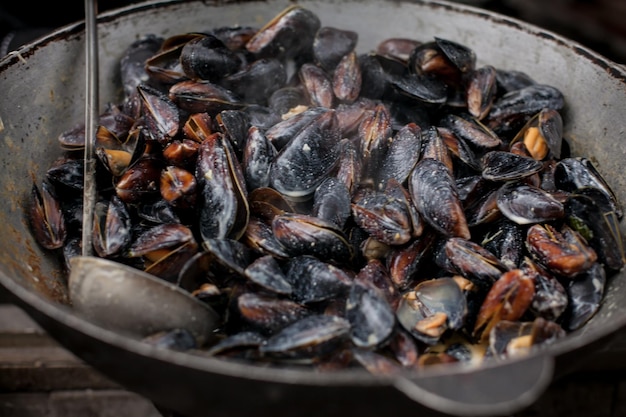 Gestoomde mosselen Verse mosselen in grillpan Veel mosselschelpen koken in grote metalen pan