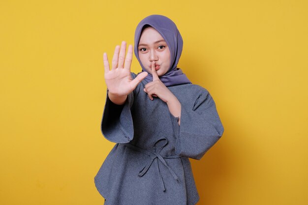 Gestopte expressie jonge vrouw die hijab draagt op gele achtergrond