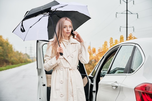 Gestopte witte auto met lekke autoband langs de weg