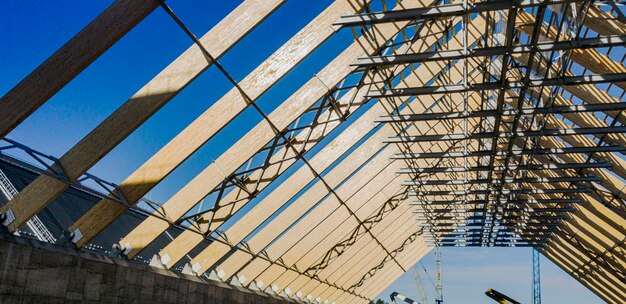 Gestraalde industriële dakbedekking en spantensysteem van houten balken. Enorme balken. De bouw van industriële gebouwen.