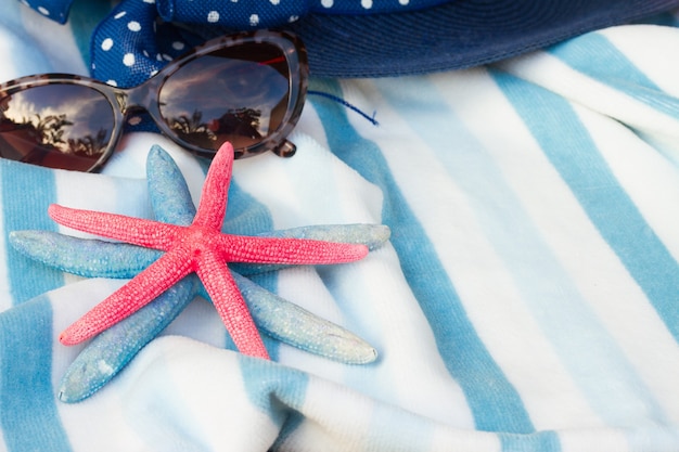 Gestreept strandlaken, roze en blauwe zeesterren en zonnebril
