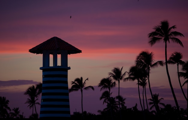 Foto gestreepte rood witte vuurtoren aan de kust van de caribische zee. dominicaanse republiek.