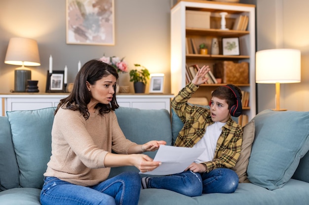 Gestresseerde moeder en zoon gefrustreerd door mislukking huiswerk schoolproblemen concept Droevige kleine jongen weggedraaid van moeder wil geen saai huiswerk doen